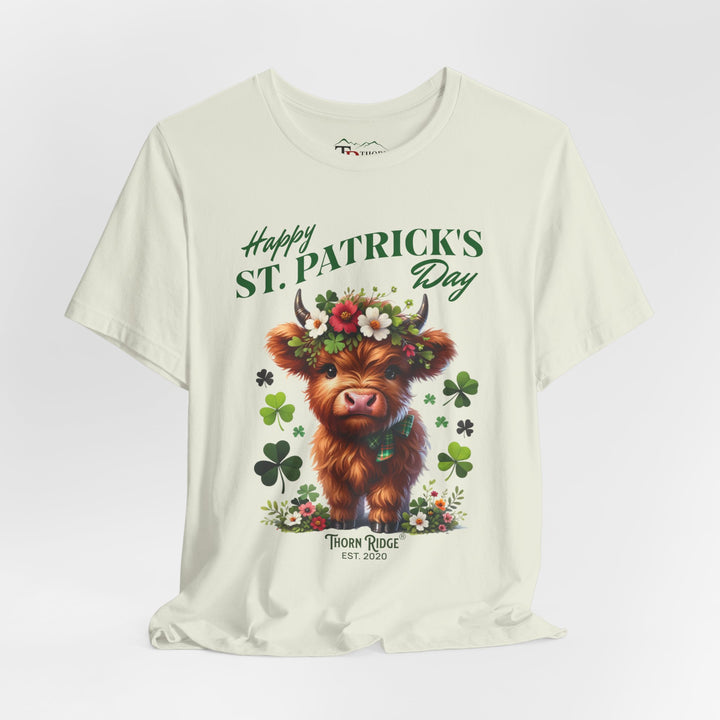 St. Patrick's Day Graphic Tee featuring a highland baby cow with flowers and clovers.