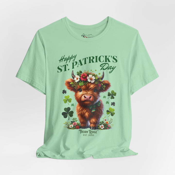 St. Patrick's Day Graphic Tee featuring a highland baby cow with flowers and clovers.