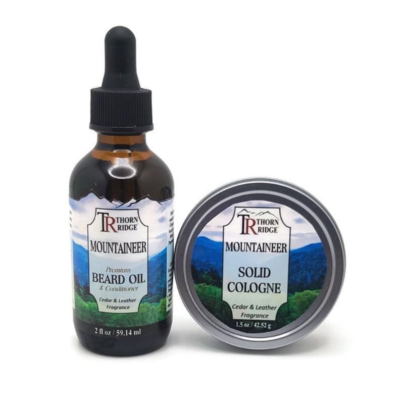 Packaging of Thorn Ridge gift set containing a 2 oz bottle of beard oil and a 1.5 oz tin can of solid cologne described as a cedar and leather fragrance and labeled "Mountaineer," Made in USA.