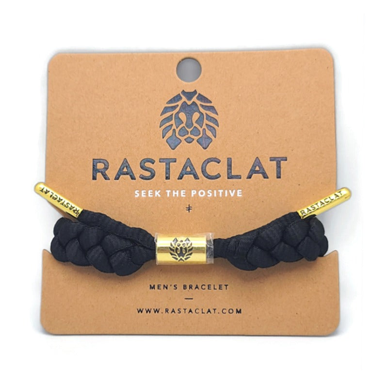 Rastaclat Men's Braided Bracelet on a tan display board, the bracelet is black with gold tips that say rastaclat and a gold circular emblem in the middle.