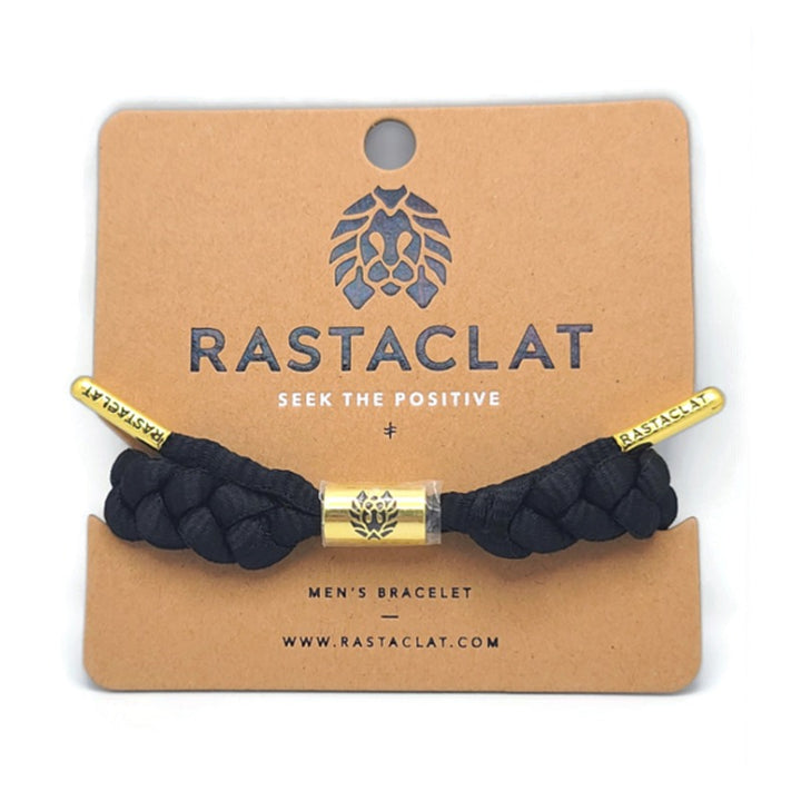 Rastaclat Men's Braided Bracelet on a tan display board, the bracelet is black with gold tips that say rastaclat and a gold circular emblem in the middle.