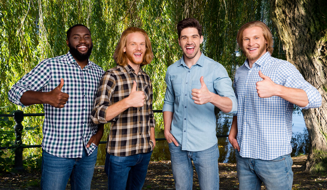 four bearded guys in standing in front of trees doing thumbs up sign
