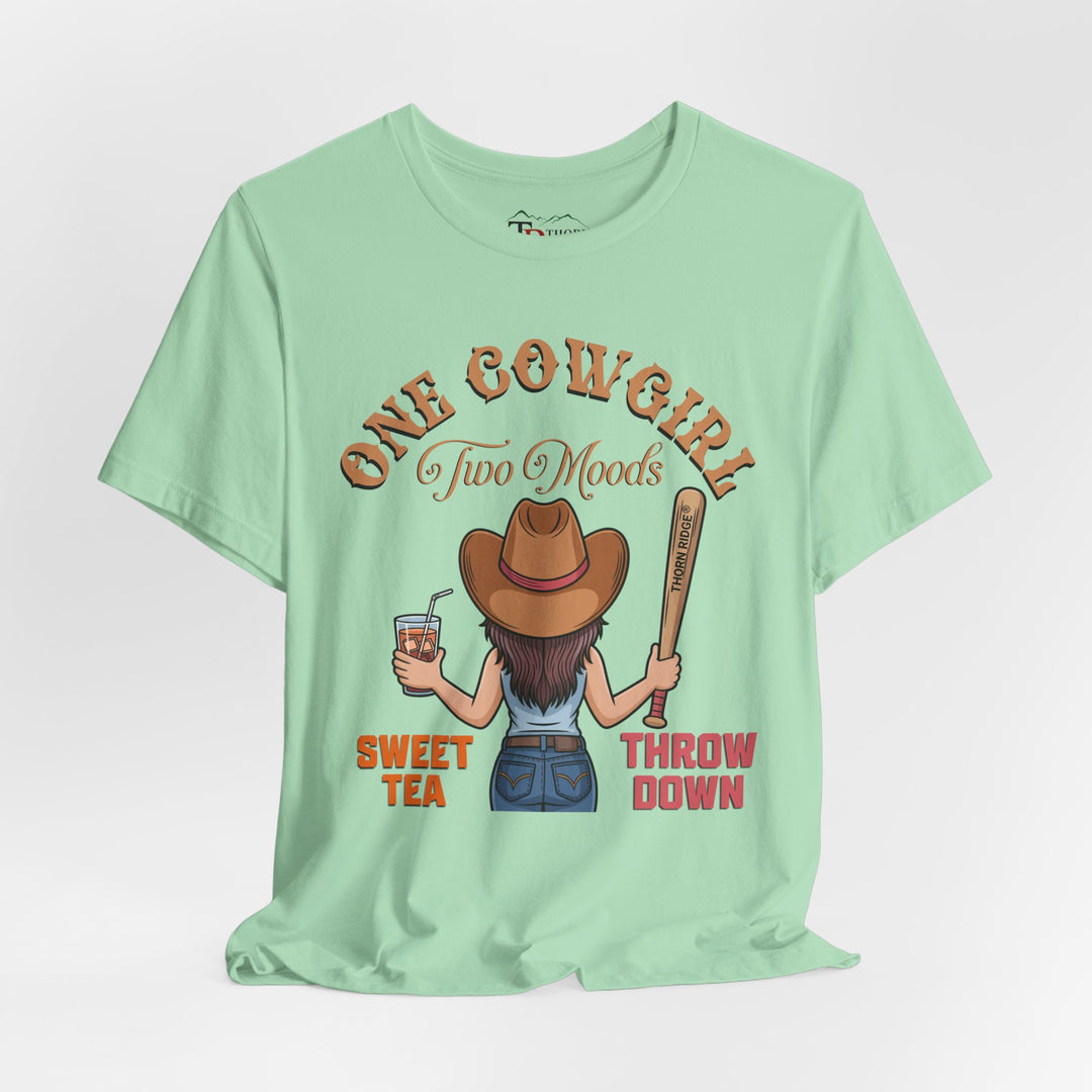 t-shirt with a graphic of a cowgirl holding a drink and a bat, with text 'One Cowgirl Two Moods Sweet Tea Throw Down' labeled Thorn Ridge®
