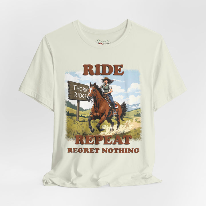 Ride Repeat Regret Nothing tee with a woman riding a galloping horse across the feild with the mountains in the background and a sign labeled Thorn Ridge®