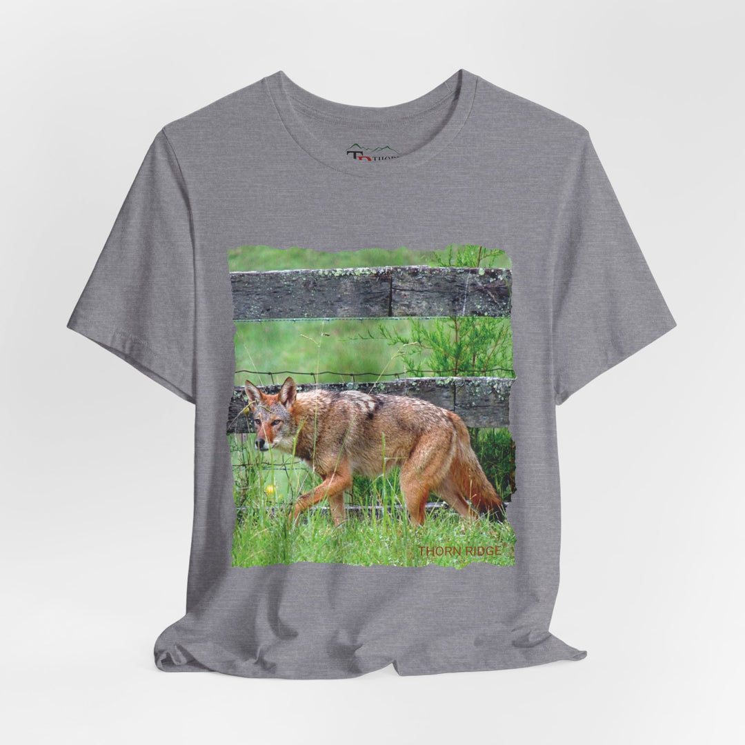 t-shirt with a photo of a red coyote against a weathered board fence and green grass labeled Thorn Ridge®