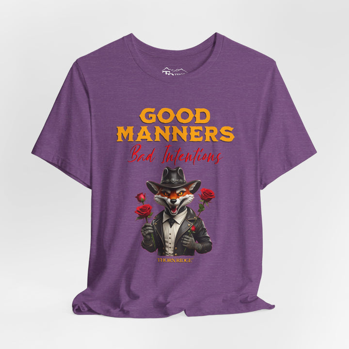 Good manners bad intentions graphic tee with a grinning fox wearing a black cowboy hat and leather jacket with human hands holding roses.  labeled Thorn Ridge®