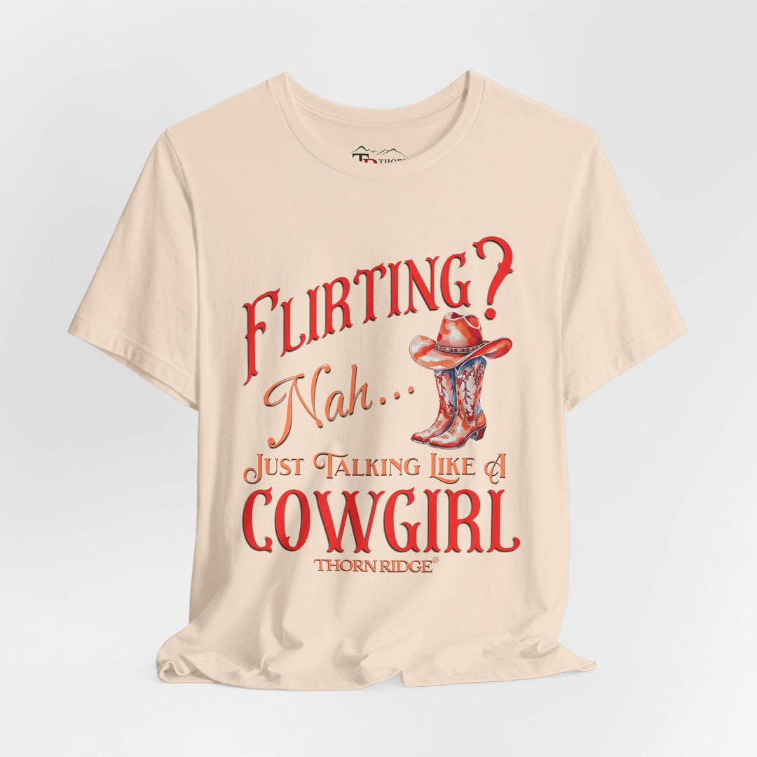 "Flirting? Nah... just talking like a cowgirl" graphic tee with women's cowgirl boots with a cowgirl hat sitting on top. Labeled Thorn Ridge®