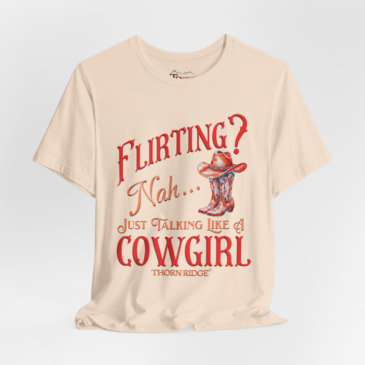 "Flirting? Nah... just talking like a cowgirl" graphic tee with women's cowgirl boots with a cowgirl hat sitting on top. Labeled Thorn Ridge®