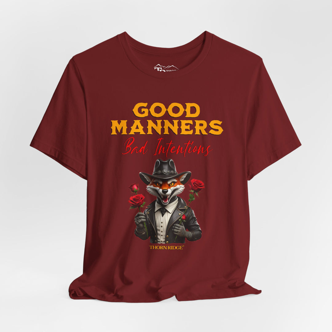 Good manners bad intentions graphic tee with a grinning fox wearing a black cowboy hat and leather jacket with human hands holding roses.  labeled Thorn Ridge®