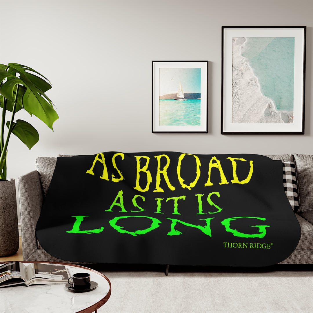 Black sherpa blanket with yellow and green text 'AS BROAD AS IT IS LONG' and 'THORN RIDGE' branding.