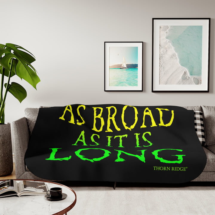Black sherpa blanket with yellow and green text 'AS BROAD AS IT IS LONG' and 'THORN RIDGE' branding.