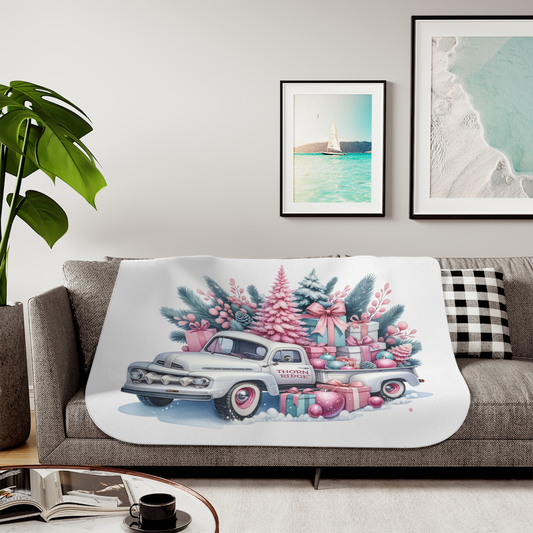 Vintage truck decorated with Christmas trees and presents on a white background with Thorn Ridge® branding on the door. Lying across a couch with a plant and pictures on the wall.