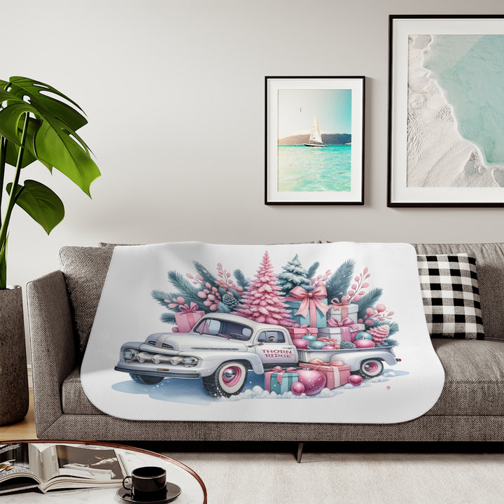 Vintage truck decorated with Christmas trees and presents on a white background with Thorn Ridge® branding on the door. Lying across a couch with a plant and pictures on the wall.