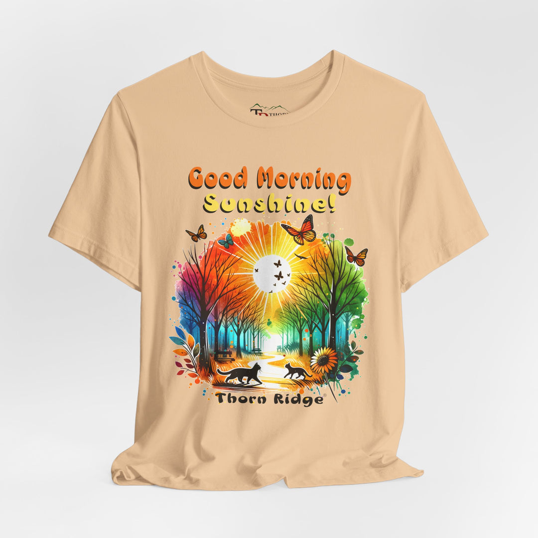 good morning sunshine graphic tee by Thorn Ridge featuring the sun shining through the trees and two cats walking across the path in a park.