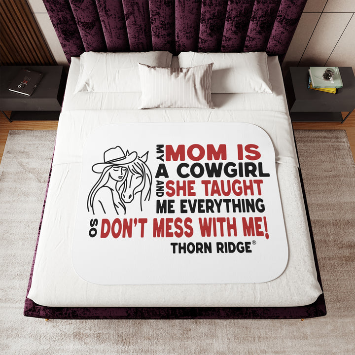 Mom Is A Cowgirl and she taught me everything so don't mess with me slogan graphic with a outline drawing of a woman with a cowboy hat hugging a horse by Thorn Ridge®