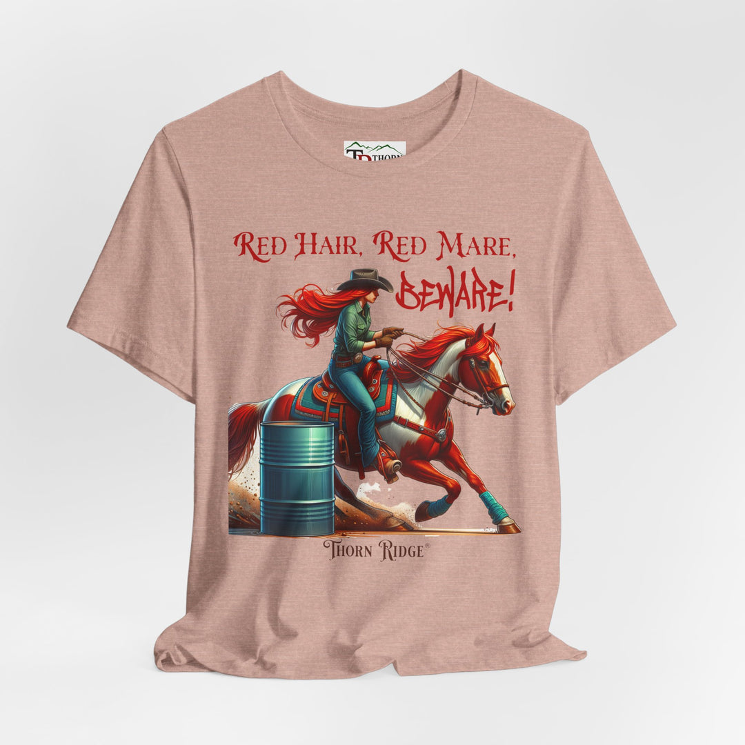 t-shirt with a graphic of a redhead woman on a horse barrel racing and the text 'Red Hair, Red Mare, Beware!' labeled Thorn Ridge®.
