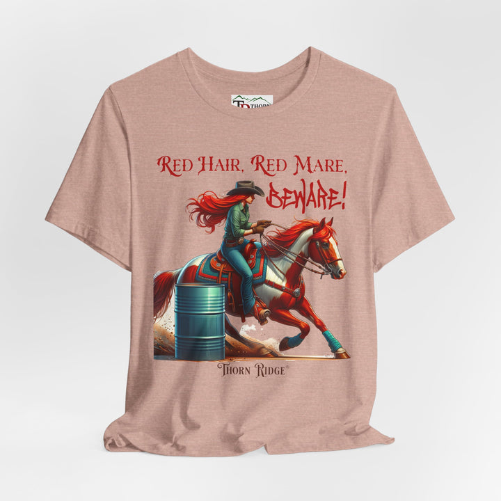 t-shirt with a graphic of a redhead woman on a horse barrel racing and the text 'Red Hair, Red Mare, Beware!' labeled Thorn Ridge®.