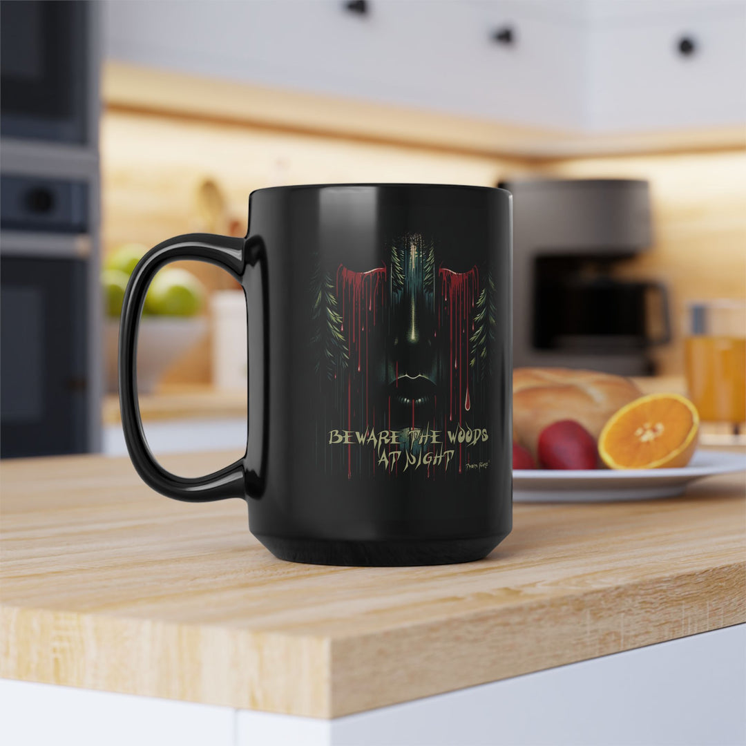 Black mug with a face emerging from the forest with bleeding eyes and a warning Beware the Woods at Night by Thorn Ridge®