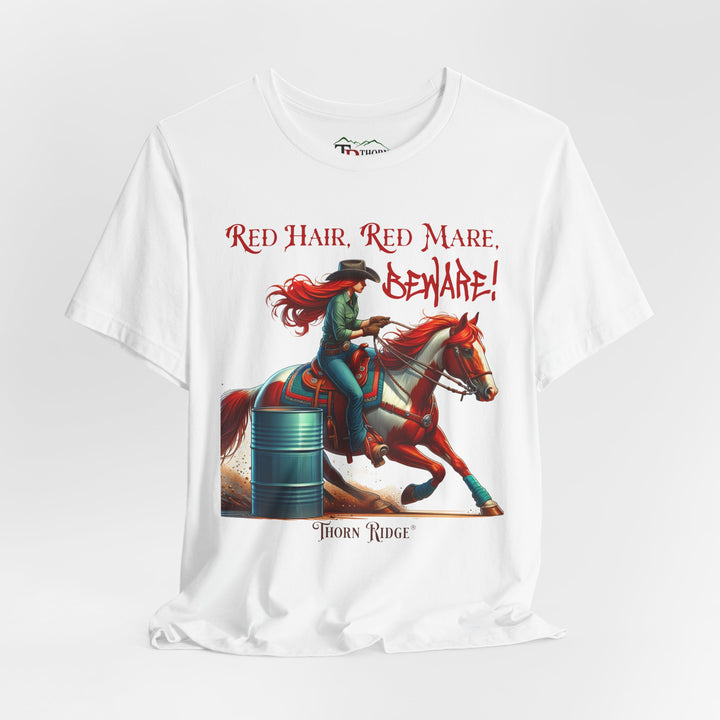 t-shirt with a graphic of a redhead woman on a horse barrel racing and the text 'Red Hair, Red Mare, Beware!' labeled Thorn Ridge®.