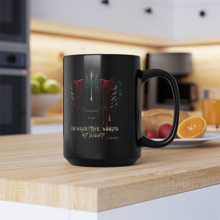Black mug with a face emerging from the forest with bleeding eyes and a warning Beware the Woods at Night by Thorn Ridge®