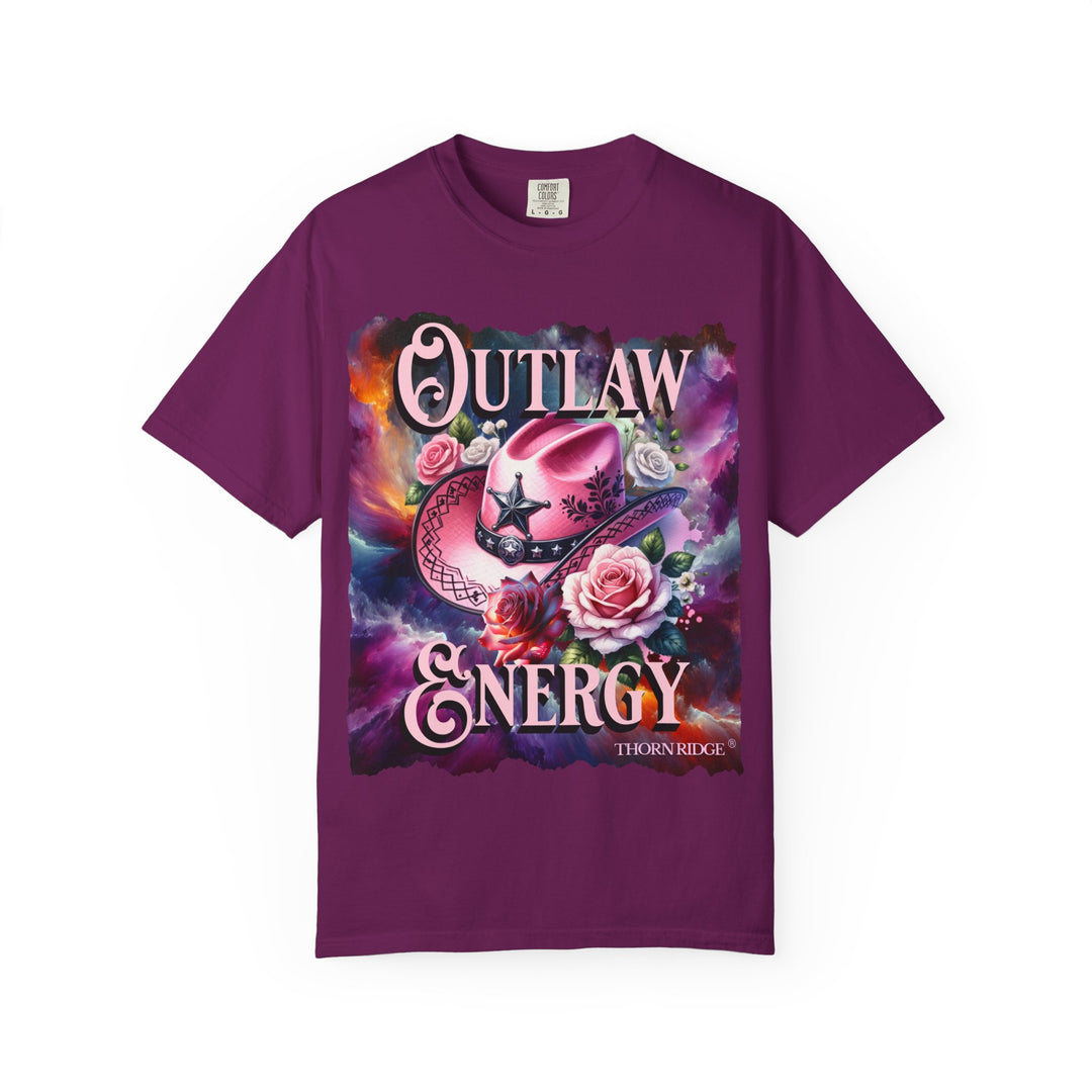 Outlaw Energy graphic tee with a pink cowgirl hat and roses on a celestial background of pinks, blues, and oranges. Labeled Thorn Ridge®