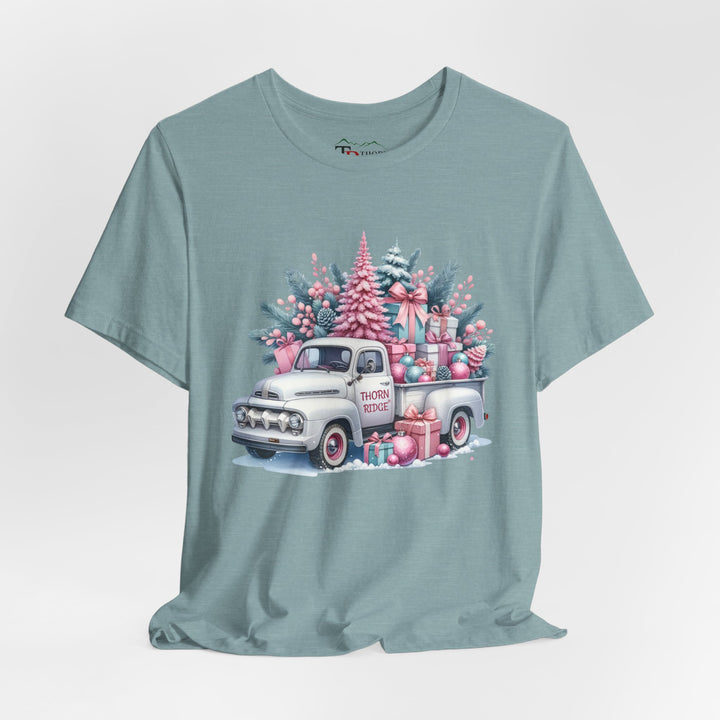 t-shirt with a vintage white truck with the bed filled with pastel colored christmas trees and presents with Thorn ridge on the driver's side door and presents around the door on the ground. 