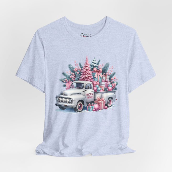 t-shirt with a vintage white truck with the bed filled with pastel colored christmas trees and presents with Thorn ridge on the driver's side door and presents around the door on the ground. 