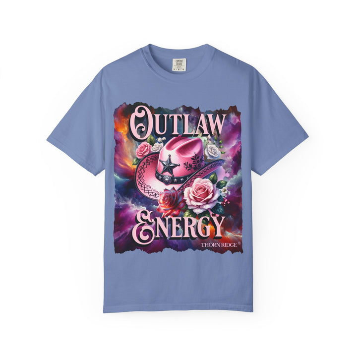Outlaw Energy graphic tee with a pink cowgirl hat and roses on a celestial background of pinks, blues, and oranges. Labeled Thorn Ridge®