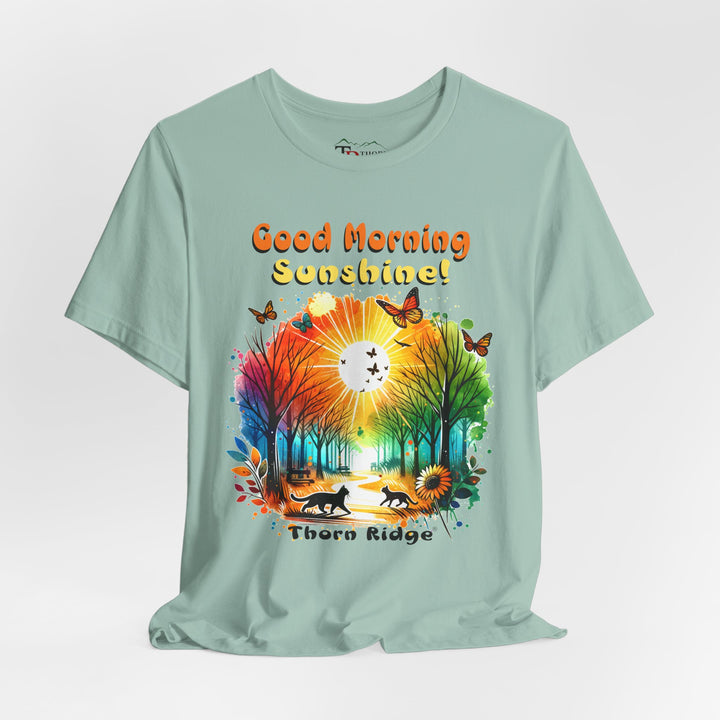 good morning sunshine graphic tee by Thorn Ridge featuring the sun shining through the trees and two cats walking across the path in a park.