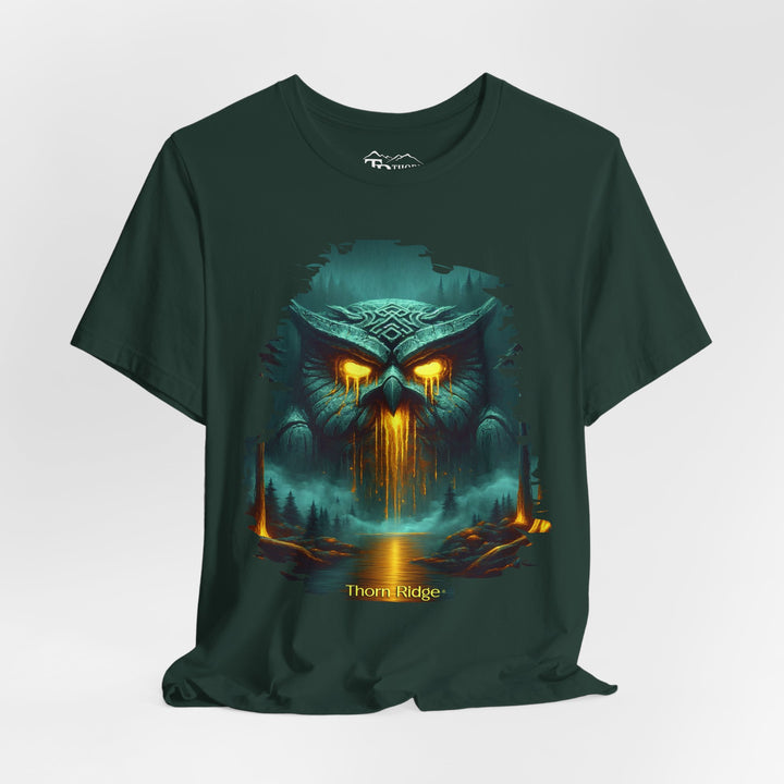 Legend of the Owl King tee by Thorn Ridge with a ancient statue of an owl with glowing lava eyes and mouth in front of a river with fog in the forest. 