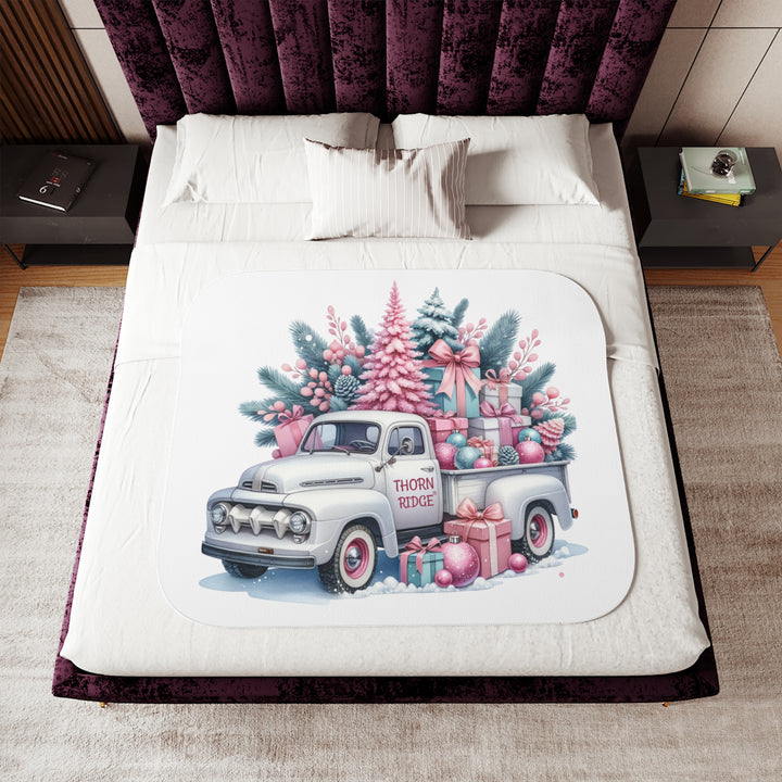 Vintage truck decorated with Christmas trees and presents on a white background with Thorn Ridge® branding on the door. Lying across a bed