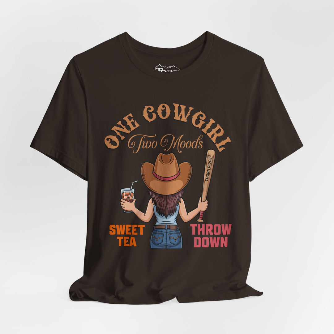 t-shirt with a graphic of a cowgirl holding a drink and a bat, with text 'One Cowgirl Two Moods Sweet Tea Throw Down' labeled Thorn Ridge®