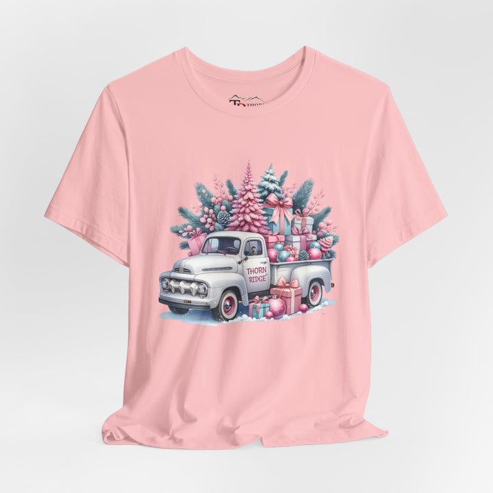 t-shirt with a vintage white truck with the bed filled with pastel colored christmas trees and presents with Thorn ridge on the driver's side door and presents around the door on the ground. 