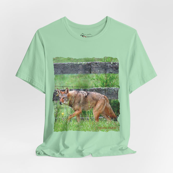 t-shirt with a photo of a red coyote against a weathered board fence and green grass labeled Thorn Ridge®