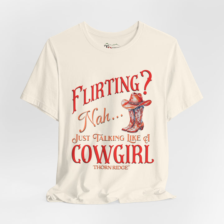 "Flirting? Nah... just talking like a cowgirl" graphic tee with women's cowgirl boots with a cowgirl hat sitting on top. Labeled Thorn Ridge®