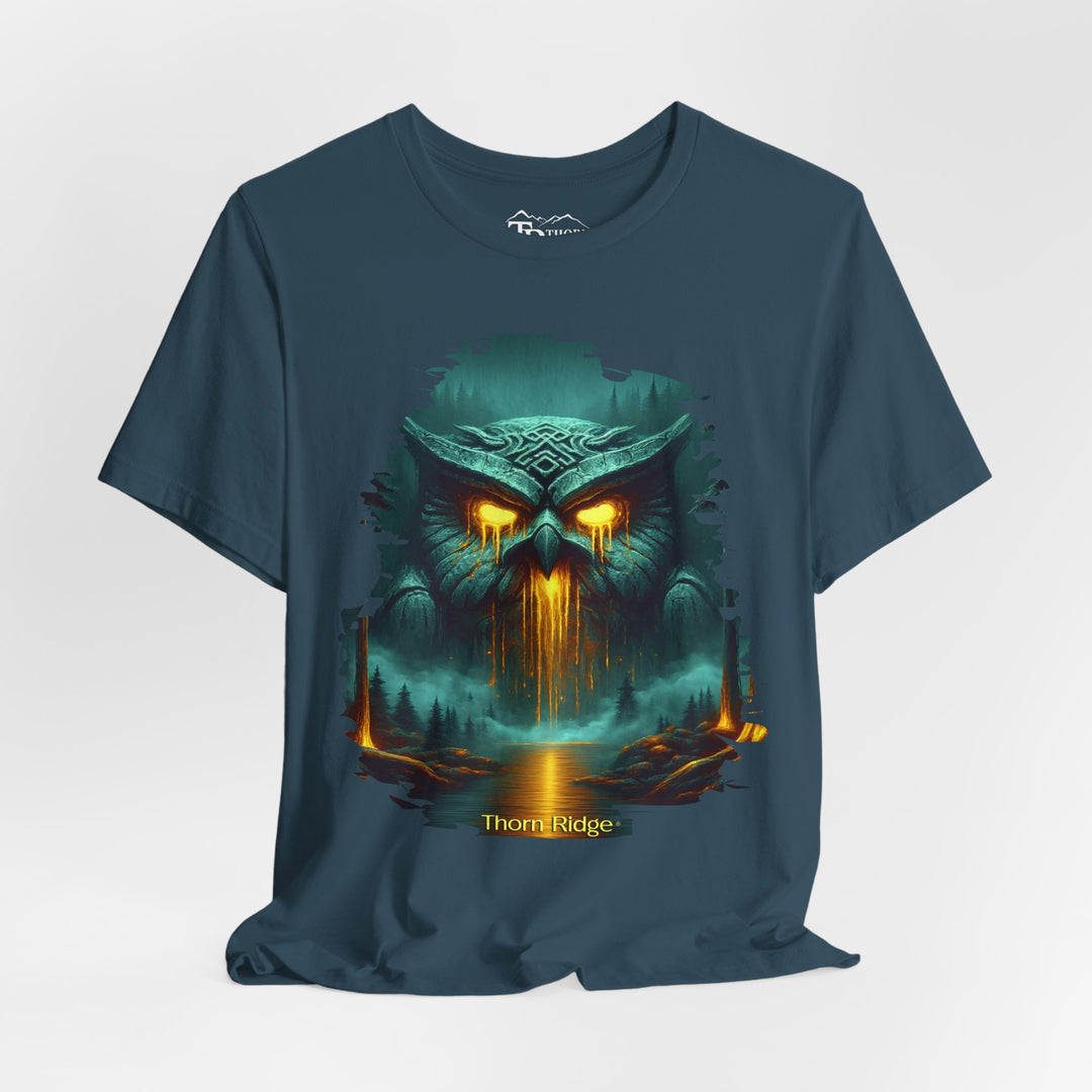 Legend of the Owl King tee by Thorn Ridge with a ancient statue of an owl with glowing lava eyes and mouth in front of a river with fog in the forest. 