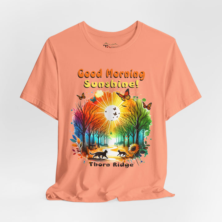 good morning sunshine graphic tee by Thorn Ridge featuring the sun shining through the trees and two cats walking across the path in a park.