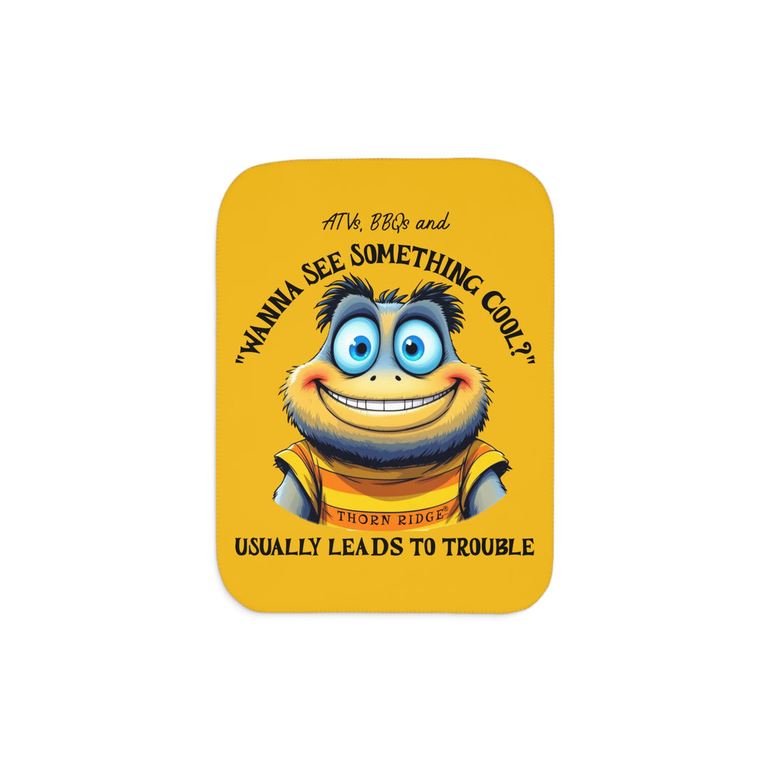 Wanna See Something Cool illustration with a big eyes wide smiled character on a yellow Sherpa Blanket with 'Thorn Ridge' branding. 