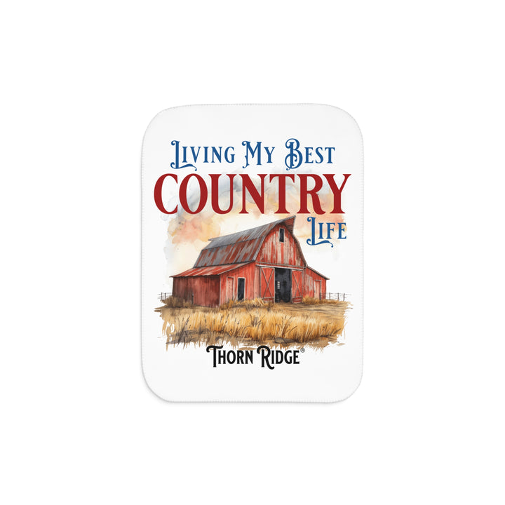 White Sherpa Blanket with a barn illustration and text 'Living My Best Country Life' by Thorn Ridge on a white background.