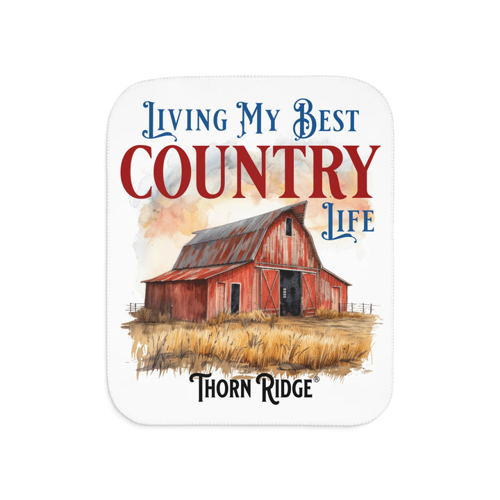 White Sherpa Blanket with a barn illustration and text 'Living My Best Country Life' by Thorn Ridge on a white background.