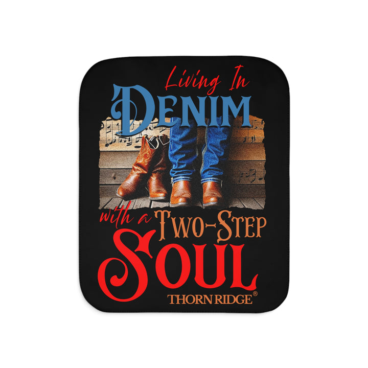 Black Sherpa blanket with text 'Living In Denim, with a Two-Step Soul by Thorn Ridge® and images of someone wearing jeans and boots from the shins down against a wooden wall with music notes on it and a empty pair of boots leaning against the man's leg.