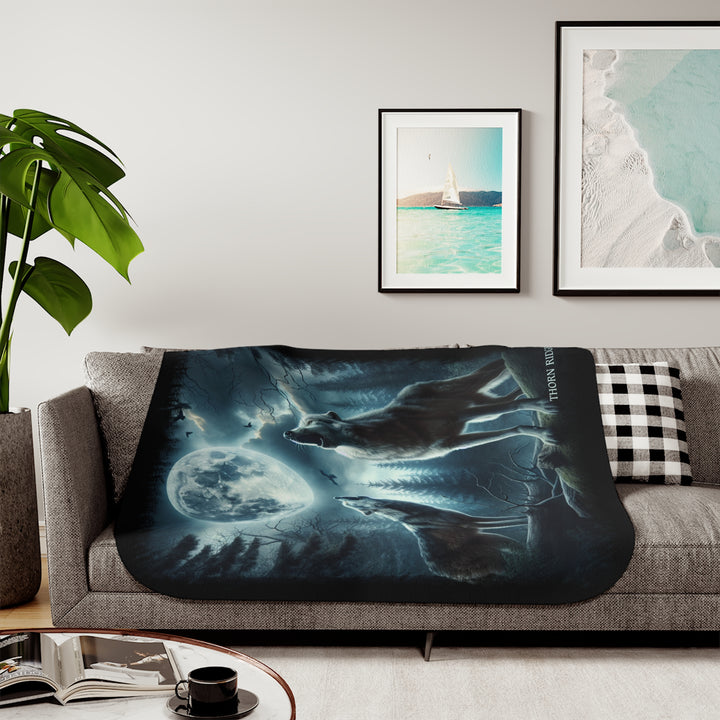 Moonlit Wolves sherpa blanket by Thorn Ridge® featuring two gray wolves deep in the forest howling at the moon with black birds flying around in the sky.