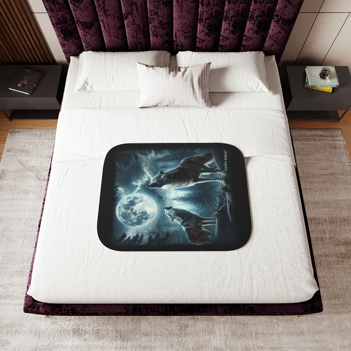 Moonlit Wolves sherpa blanket by Thorn Ridge® featuring two gray wolves deep in the forest howling at the moon with black birds flying around in the sky.