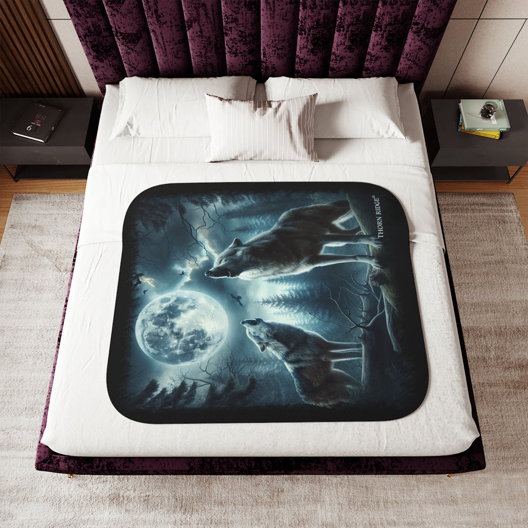Moonlit Wolves sherpa blanket by Thorn Ridge® featuring two gray wolves deep in the forest howling at the moon with black birds flying around in the sky.