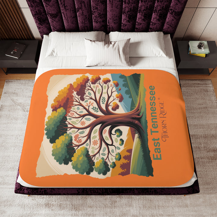 Orange sherpa blanket with an autumn tree design and East Tennessee and branded Thorn Ridge®