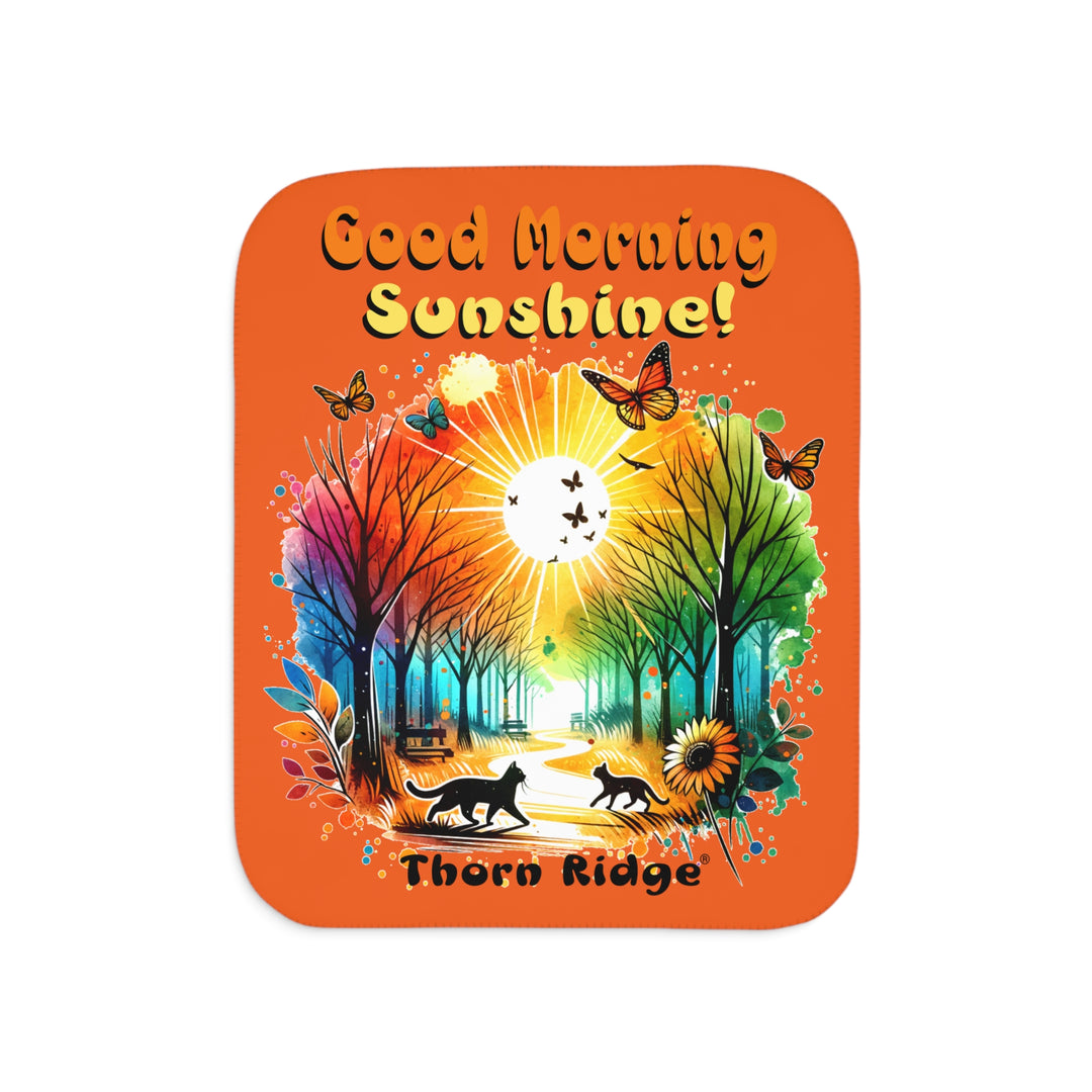 Colorful design of two cats in a park at sunrise with 'Good Morning Sunshine!' text on an orange sherpa blanket and branded Thorn Ridge®