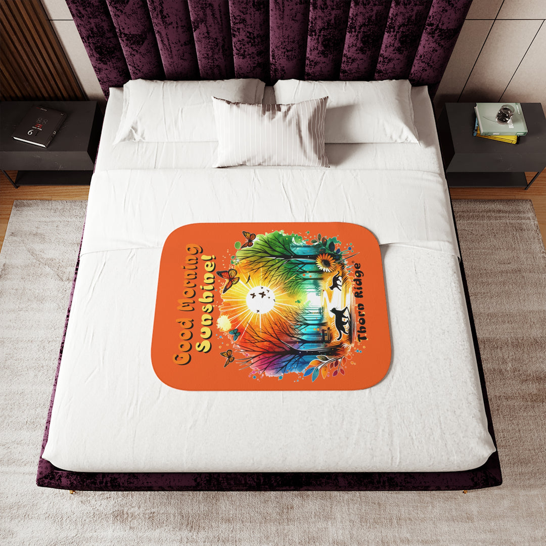 Colorful design of two cats in a park at sunrise with 'Good Morning Sunshine!' text on an orange sherpa blanket and branded Thorn Ridge®