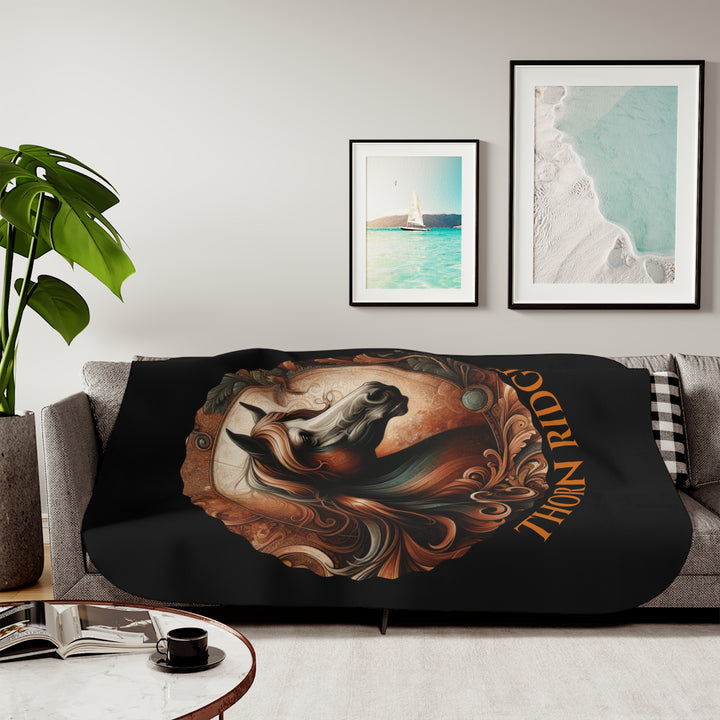 Decorative and elegant horse design in brown and green tones with 'Thorn Ridge®' branding on a black sherpa blanket.