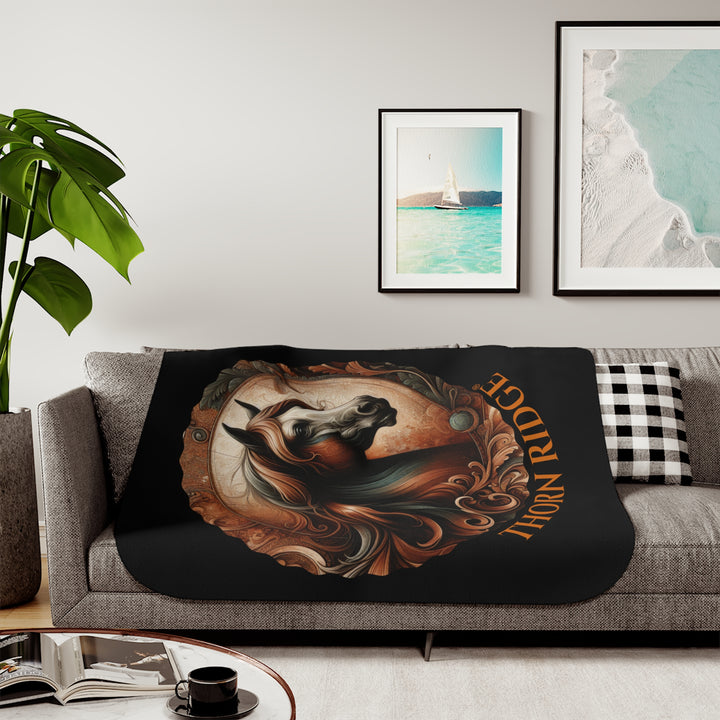Decorative and elegant horse design in brown and green tones with 'Thorn Ridge®' branding on a black sherpa blanket.