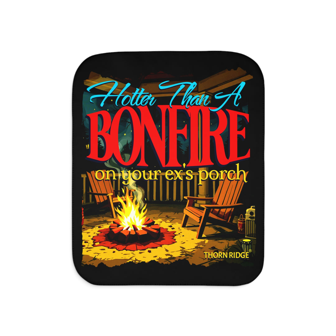 Hotter than a bonfire on your ex's porch slogan by Thorn Ridge® on a black sherpa blanket with the image of a bonfire on a porch.